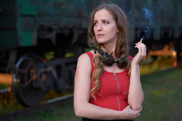 portrait of a girl with a cigarette on the background of a train