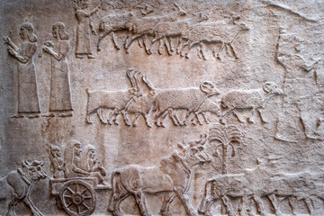 Ancient persian bas-relief depicting people and livestock