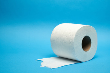 Torn off white toilet paper roll on minimalistic blue background