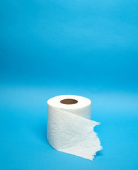Torn off white toilet paper roll on minimalistic blue background