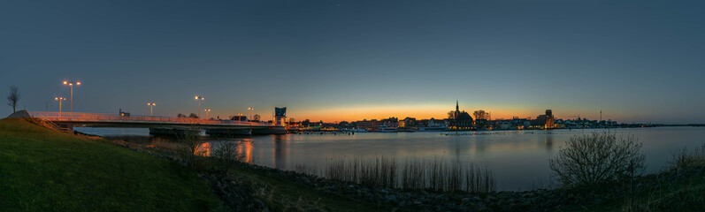 Obraz na płótnie Canvas Panoramic view of the town of Kappeln on Schlei inlet by blue hour evening, Schleswig-Holstein, Germany