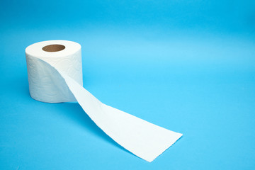Torn off white toilet paper roll on minimalistic blue background