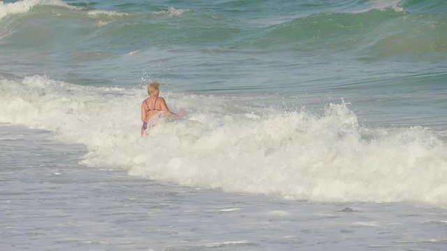 A plump woman is resting and bathing on the sea.