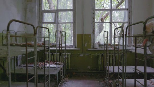 Dusty Bedroom With Empty Double Deck Beds And Old Dolls Left Inside The Abandoned Kindergarten In Pripyat During The Nuclear Disaster In Chernobyl, Ukraine - Long shot
