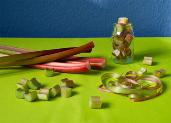 Fototapeta na wymiar Rhubarb stalks and slices for pieplant jam on green and classic blue background
