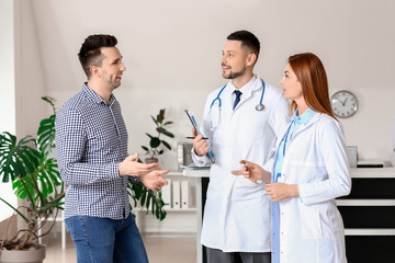 Obraz premium Doctors with patient in hall of clinic