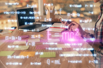 Double exposure of woman hands typing on computer and formula hologram drawing. Education concept.