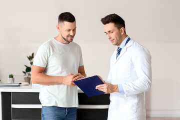 Male doctor with patient working in clinic