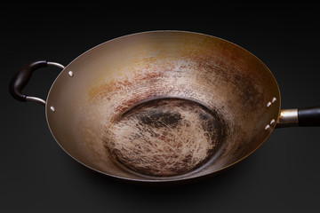 Used and seasoned wok with black background