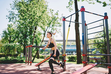 Fototapeta premium Slim athletic lady bending down in sport ground