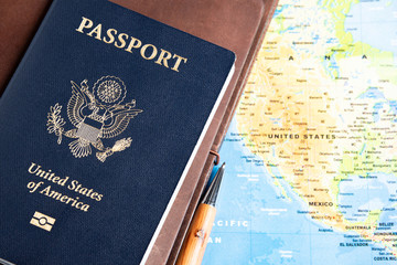 The foil-stamped dark blue front cover of an American passport set on a world map background.