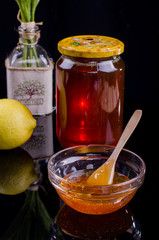Honey in a jar and tea on a wooden table