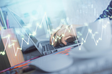 Double exposure of woman hands typing on computer and forex chart hologram drawing. Stock market invest concept.