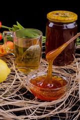 Honey in a jar and tea on a wooden table