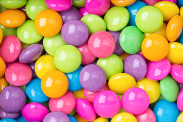 Pile of colorful sweet candy chocolates coated on white paper. colourful collection background.