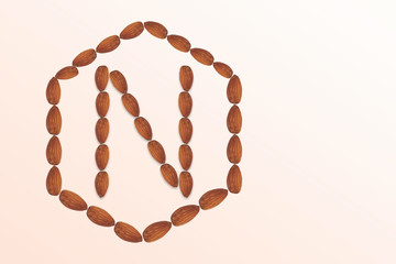 Letter N of the English alphabet from nuts in hexagon shape. Food pattern made from nuts alphabet for shop and diet