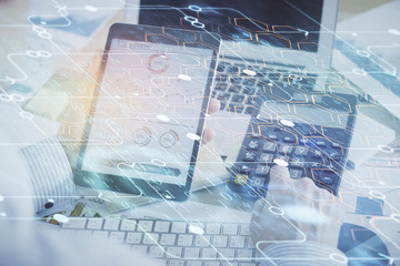 Double exposure of man's hand holding and using a digital device and data theme hologram drawing. Technology concept.