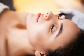 Obraz na płótnie Canvas Cute woman getting spa face mask in beauty studio