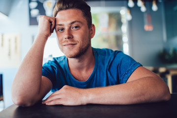 Portrait of handsome caucasian man with blue eyes and in good looking casual t-shirt resting in...