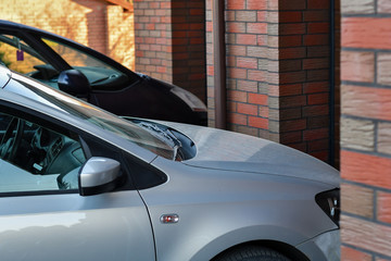 Front part of a car parked in front of the garage door. Selective focus.
