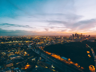 Night time view of urban setting with tall buildings and roads illuminated with outdoors lights, panoramic evening scape of megalopolis architecture and infrastructure with driveways and traffics