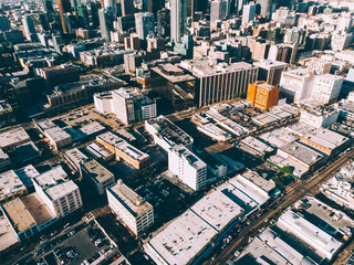 Fototapeta premium From above view of tall building and infrastructure in district of town in morning, urban setting with skyscrapers and concrete architecture in megalopolis and commercial midtown