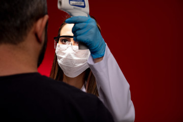 Doctor using infrared thermometer.