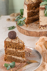 Slice of delicious naked chocolate and hazelnuts cake on table rustic wood kitchen countertop.