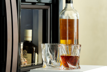 open hatch of a mini bar in a modern refrigerator. home mini bar in the fridge. a glass carafe full...