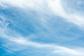 Some leaning cirrus clouds over a blue sky background
