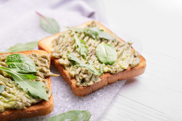 Tasty avocado sandwiches on table