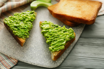 Tasty avocado sandwiches on table