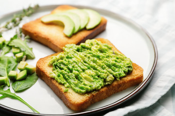 Tasty avocado sandwiches on plate