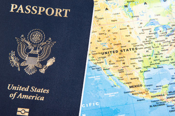 The foil-stamped dark blue front cover of an American passport set on a world map background.