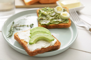 Tasty avocado sandwiches on plate