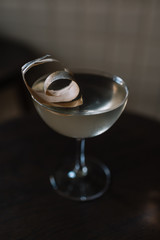 Glass of cocktail based on gin, birch juice cordial and essential oil of frankincense, decorated with a piece of birch bark. Smooth image with shallow depth of field.