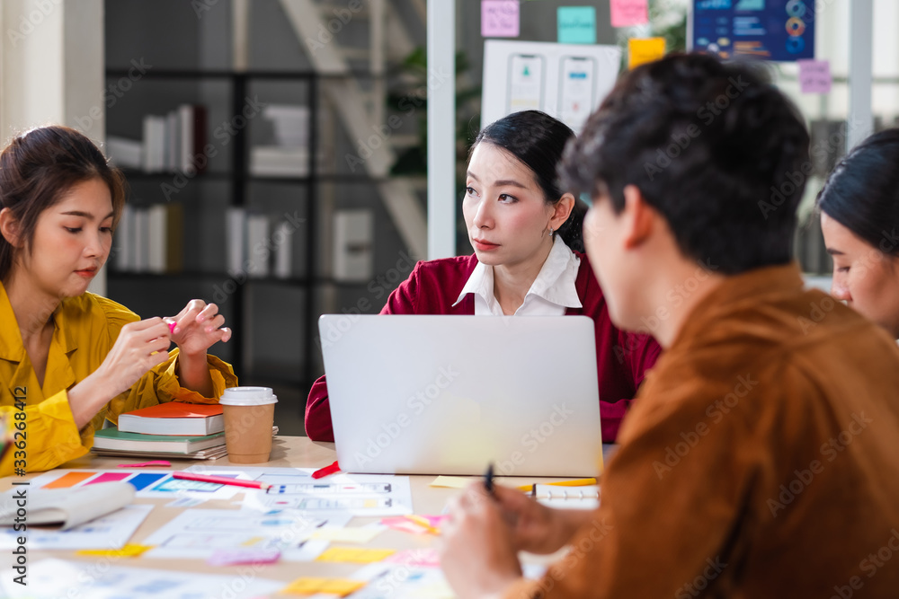 Poster ux developer and ui designer brainstorming about mobile app interface wireframe design on meeting table with customer brief and color code at modern office.Creative digital development agency