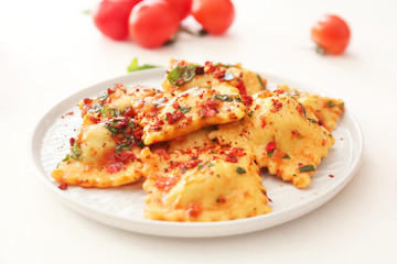 Plate with tasty ravioli on table