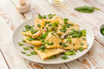 Plate with tasty ravioli on table