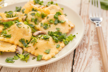 Plate with tasty ravioli on table