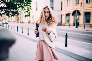 Obraz premium Pretty blonde woman surfing mobile on street