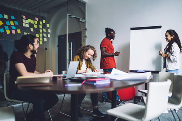 Multiracial colleagues brainstorming and working with flip chart