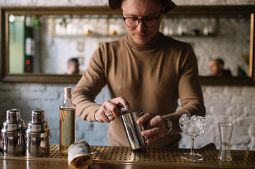 Bartender preparing cocktail based on gin, birch juice and essential oil of frankincense.