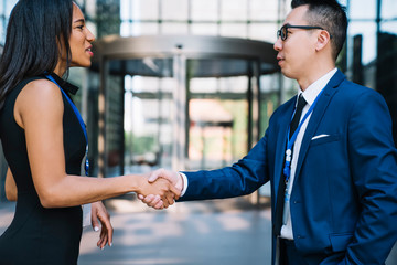 Confident Hispanic lady shaking hands making deal with partner