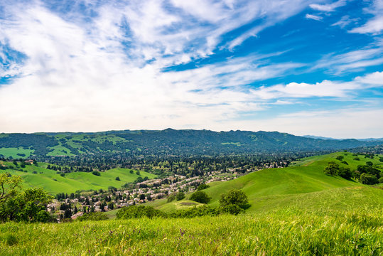 Wide angle view overlooking Camino Tassajara with hiking and walking trail on the slope of a hill in Sycamore Valley Preserve Contra Costa County Danville, California.