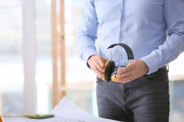 Male builder with headphones in office