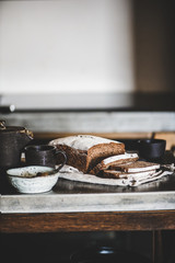 Healthy rye Swedish bread loaf cut in slices covered with flour with vintage knife on cotton towel over kitchen counter, selective focus