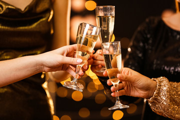 Women clinking glasses of tasty champagne at party
