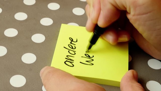 woman is writing "andere Wege gegen" (walk different ways) on a post-it