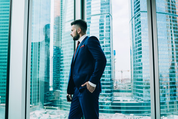 Fototapeta premium Calm businessman looking out window in office